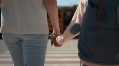 Güneşli bir sabahta okul otobüsüne birlikte yürüyoruz. Yakın çekim. Tanımlanamayan anne, kıvırcık okul çocuğuyla sarı akademik mekiğe gidiyor. Sırt çantası taşıyan sarışın ilkokul çocuğu..