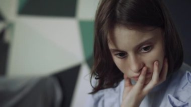 Arkadaşlarıyla oturan ciddi bir liseli kızın portresi. Odaklanmış esmer çocuk, elini yakına uzatıyor. Okul tatilinde yalnız hisseden düşünceli üzgün kız öğrenci. Arkadaşlık kavramı.