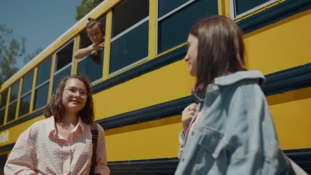 Dos Chicas Alegres Hablando Autobús Escolar Amarillo Sonrientes Compañeros Clase — Vídeo de stock