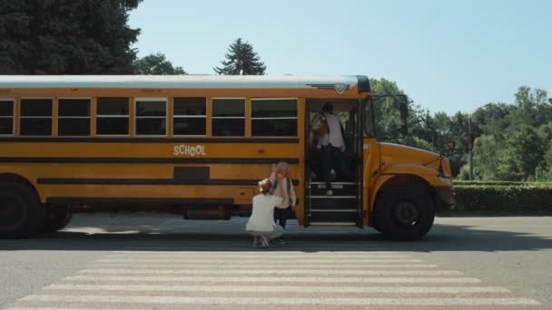 Matka Towarzyszy Synowi Szkolnym Transporcie Uczeń Wsiadający Żółtego Autobusu Słoneczny — Wideo stockowe