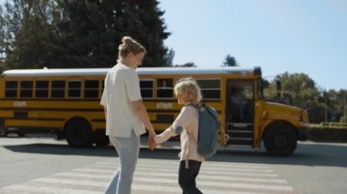 Bakıcı anne, güneşli bir sabah otobüsüne kadar oğluna eşlik ediyor. Genç anne yatılı okul otobüsünü izliyor. Mutlu kadın dalgalı kıvırcık saçlı oğlanla el çırpıyor. Sarışın, bekleyen çocukların arabası kalkıyor..