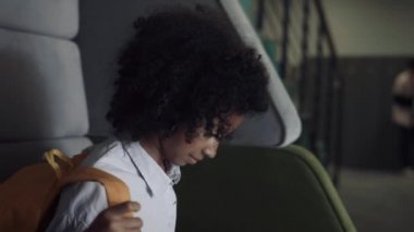 Şirin afro-amerikan ergen kız bankta tek başına oturuyor. Okul koridorundaki derslerden sonra güzel kız sırt çantasını çıkarıyor. Kıvırcık yaratıcı öğrenci resim çizmek için çizim defterini çıkardı..