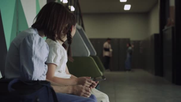 Dos Colegialas Alegres Sosteniendo Almohadilla Inteligente Pasillo Escuela Chicas Curiosas — Vídeos de Stock