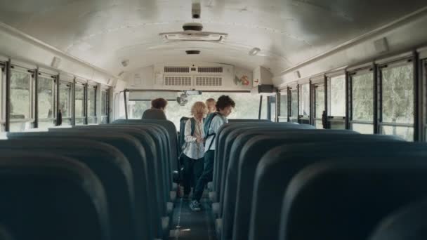 在校车上住宿的多族裔学童 快乐的孩子们在校车上就座 小学快乐的学生进入汽车沙龙 公共教育交通概念 — 图库视频影像