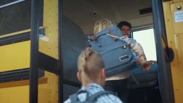 Többnemzetiségű Gyerekek Szállnak Fel Sárga Iskolabuszra Koncentrált Férfi Sofőr Vizsgálja — Stock videók
