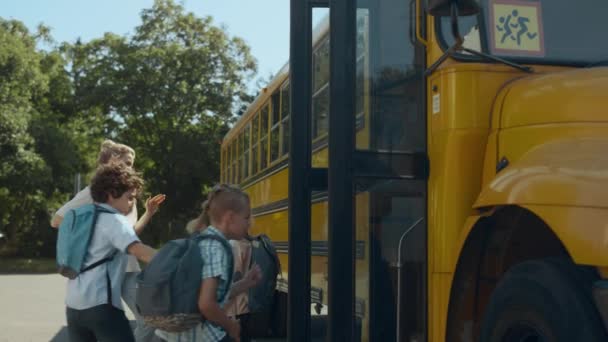 Mãe Sorridente Com Filho Dando Alta Cinco Perto Ônibus Escolar — Vídeo de Stock