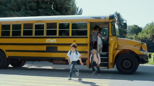 Усміхнені Студенти Початкового Віку Залишають Жовтий Шкільний Автобус Веселі Різноманітні — стокове відео