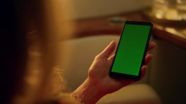 Jette yeşil ekran cep telefonu çalan bir kadın. Akıllı telefonlara yakın çekim. Tanımlanamayan orta yaşlı kullanıcı haberlerini kontrol ederek sosyal medyayı tarıyor. Lüks kadın iş gezisinde yeşil cihaz kullanıyor.