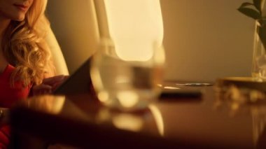 Tablet bilgisayarına dokunan odaklanmış bir kadın. Güzel bayan parşömen kağıdı uçak penceresinde. Sarışın iş kadını internette geziniyor. Özel jet yolcusu sosyal medyayı kontrol ediyor