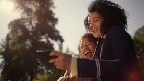 Mãe Rindo Segurando Smartphone Assistindo Fotos Engraçadas Selfie Juntos Parque — Fotografia de Stock