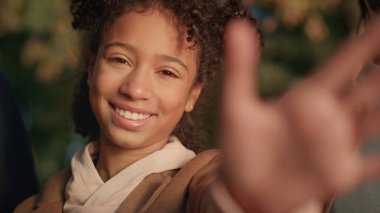 Portre kızı, altın güneş ışığında elini uzatıp kameraya bakıyor. Hayalperest şirin çocuk. Afro-Amerikan mutlu kızı tatmin olmuş, sıcak aile akşamlarını parkta geçiriyor. Romantik ruh hali kavramı