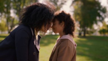 Sevimli bir kız el ele tutuşmuş, şefkatli bir anne. Koşulsuz aşk kavramı. Afro-Amerikan kadınlarının aile pikniğinde burunlarına dokunması. Duygusal bağ kuran çocuk anne.