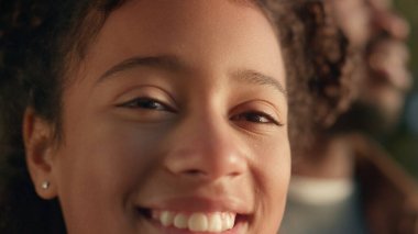 Yakından gülümseyen kız ışıl ışıl parlayan gözlere bakıyor. Rahatlatıcı neşeli çocuk. Neşeli Afrikalı Amerikalı kız mutlu kız babasıyla iyi vakit geçiriyor. Tasasız çocukluk konsepti.