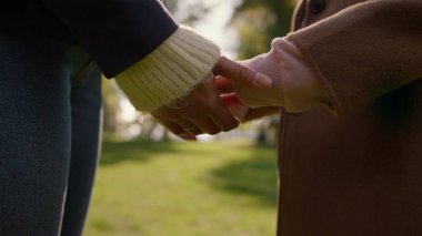 Annenin elleri sonbahar parkında kızına katılıyor. Sevgi dolu ebeveyn desteği. Bilinmeyen Afrikalı Amerikalı kadın anne çocuk koluna nazikçe dokunuyor koşulsuz sevgiyi ifade ediyor. Duygusal bağlantı kavramı.