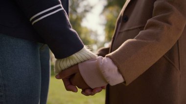 Ebeveyn elleri, çocuk kolu yeşil parkı kapatıyor. Duygusal ayrılık sorunu. Tanınmayan Afro-Amerikan anne kadın, kızının ellerini nazikçe ayırıyor. Aile çocuğu iletişim sorunu.