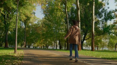 Rahatlamış ebeveynler bebek arabasının arka camını iterek parkta yürüyorlar. Mutlu aile günleri. Neşeli Afro-Amerikalı kız atlayarak akşam güneşinin tadını çıkarıyor. Önemseyen anne ve baba sokak sohbetine gidiyor..