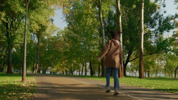 Rahatlamış ebeveynler bebek arabasının arka camını iterek parkta yürüyorlar. Mutlu aile günleri. Neşeli Afro-Amerikalı kız atlayarak akşam güneşinin tadını çıkarıyor. Önemseyen anne ve baba sokak sohbetine gidiyor..