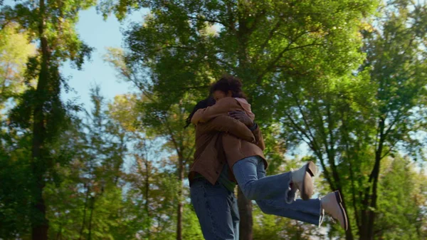 Mutlu baba kızını döndürüyor, küçük çocuğa sarılıyor. Sunny Park 'ta oynayan bir aile. Neşeli Afrikalı Amerikalı adam, babasını seviyor ve tatlı kıvırcık çocuğu kucaklıyor. Duygusal bağ tasasız çocukluk kavramı.