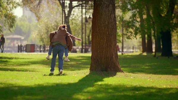 Glückliche Eltern Huckepack Tochter Sonnigen Frühlingspark Liebevolles Vaterwochenende Verspielt Lächelnde — Stockfoto