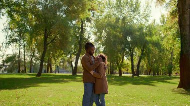 Gülümseyen ebeveyn kızı nazikçe çocuğa dokunuyor. Koşulsuz baba sevgisi. Yakışıklı Afrikalı Amerikalı baba mutlu çocuğu kucaklıyor ve parkta eğleniyor. Ebeveynlik duygusal bağlılık kavramı.