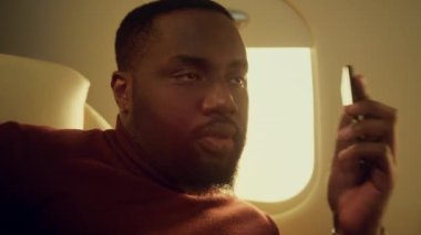Mutlu adam uçak penceresinden çağrı alıyor. Şirket gezisinde gülümseyen iş ortağı konuşuyor. Neşeli Afro-Amerikan yolcu uçak yolculuğunda akıllı telefon kullanarak dinleniyor..