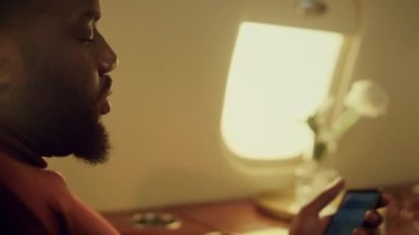 Akıllı telefon çizelgesi kullanan ciddi bir yönetici. Yakından cep telefonu tutan eller. Hayal kırıklığına uğramış Afrikalı Amerikalı iş adamı internette satış verilerini kontrol ediyor. Şirket seyahatinde başarılı bir yolcu işi.