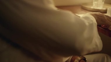 Tanınmayan zengin adam birinci sınıfta cep telefonuna dokunuyor. Arap işadamı elinde krom ekranlı akıllı telefonu yakın planda tutuyor. Sakallı yolcu dinlenme cihazı..