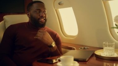 Başarılı bir Afrikalı Amerikalı adam yakın planda seyahat ediyor. Gülümseyen sakallı adam pencereye bakıyor ve birinci sınıf kamarada tatil yapmayı düşünüyor. Kendine güvenen mutlu iş adamı iş gezisinin tadını çıkarıyor.