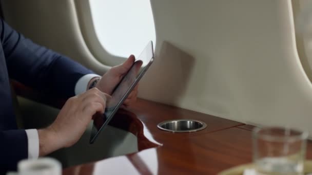 以私人飞机为重点的投资人工作平板电脑 在公司旅行时 便衣人员用手触摸垫子 认真优雅的商人使用数字计算机浏览网络 漂亮的Ceo检查在线报告 — 图库视频影像