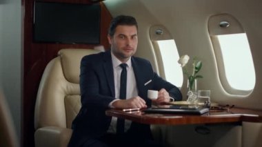 Gülümseyen CEO uçak penceresinde tek başına poz veriyor. Başarılı bir adam, şirket seyahatinin tadını çıkarır. Kendine güvenen şık bir işadamı birinci sınıf lüks içinde uçuyor. Zarif beyefendi yolculukta dinleniyor.