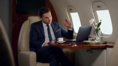 Ciddi bir iş adamı özel jetin video görüşme ortağı. Odaklanmış CEO sohbetleri online şirket gezisi. Maliye uzmanı takım elbise içinde sanal konferansta selam veriyor. İş görüşmeleri kavramı