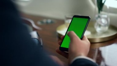 İşadamı el kamerasıyla yeşil akıllı telefon ekranını kapatıyor. Adam uçak yolculuğunda model cihazı kullanıyor. Tanınmayan başarılı adam krom telefona dokunuyor. Haberleri okuyan yolcular sosyal medyayı kontrol ediyor