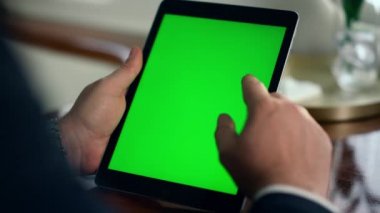 Yönetici yeşil tablet ekranı araklıyor. İnternette sörf yapan adam dijital bilgisayarda geziniyor. Tanınmayan orta yaşlı profesyonel krom tuşlu ekran. Çevrimiçi iş konsepti