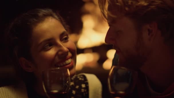 衣冠楚楚的夫妻约会时喝酒 夫妇俩笑着在壁炉边放松一下 微笑的情人喜欢浪漫的蜜月庆祝活动 情侣们笑着在假日聊天 幸福的爱情概念 — 图库视频影像