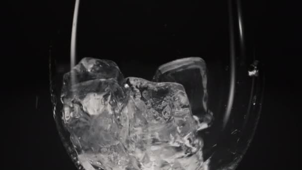 速度慢 速度慢 速度慢 速度慢 速度慢 冰块裂开的立方体倒入透明的跌落玻璃中 冷饮和鸡尾酒宏观黑色背景 口渴者概念 — 图库视频影像