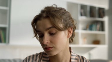 Öğrenci Webinar 'ın evini yakından izliyor. Ciddi kız sabah web kamerasına bak. Güzel bir milenyum kadını tek başına ders çalışmayı öğrenir. Gündüz makyajlı çekici bir sarışın. Uzaktan eğitim kavramı