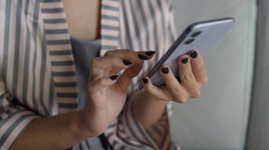 Blogcu eller pijamalı akıllı telefon tutuyor. Müdür kahvaltıdan önce e-postaları kontrol ediyor. Bilinmeyen kadın ekran izleme bloguna dokunuyor. Sabahları internette sörf yapan kız.