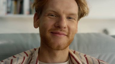 Kapalı kapılar ardında hafta sonu evde poz veren kızıl adam. Hayalperest adam rahat koltukta dinleniyor. Başarılı bir iş adamı şirketi CEO 'su, tatil gününde pijamalarıyla sabah vaktinin tadını çıkarıyor. Gülümseyen sakallı serbest çalışan kameraya bak.