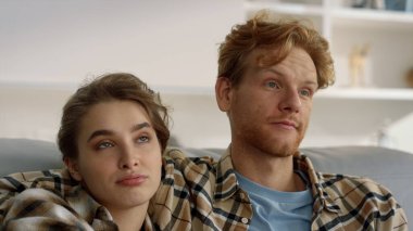 Aile kucaklaşması, birlikte film izlemek, yakın çekim. Heyecanlı çift hayal kırıklığına uğrar. Güzel, sıkılmış kız gözlerini deviriyor. Gülen kızıl adam gülüyor. Oturma odasında güzel bir kadınla TV şovunun keyfini çıkarıyor.. 