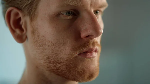 Ginger businessman looking distance closeup. Man studying document thoughtfully. Handsome bearded freelancer reading emails watching online show on computer monitor. Serious face expression concept.