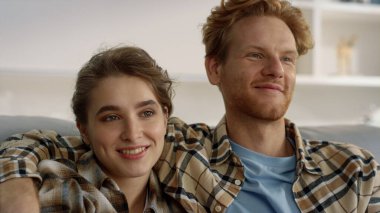 Romantik çift yakın plan film akşamının tadını çıkarır. Sevgi dolu aile kanepesi. Gülümseyen kızıl adam evde güzel kız arkadaşına sarılıyor. Neşeli öğrenciler çevrimiçi blog içeriğini rahat bir yerde izliyorlar. 