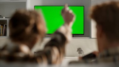 Video oyunları televizyon krom anahtarı oturma odasında. Kimliği belirsiz kadın evdeki online konsol yarışmasında yenilen adamı kutluyor. Oyun oynayan çiftler. Oyun oynayan çiftler. Mockup düz ekran aygıtı