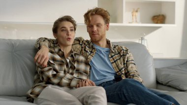 Kocası rahat bir evde televizyon kanalını değiştiriyor. Mutlu çift karantinada akşamın tadını çıkarır. Gençler oturma odasında televizyon izleme platformu seyrederek sarılıyorlar. Hafta sonları ailecek vakit geçiririz.