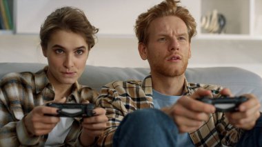 Oyuncular oyun bloknotlarını eve yakın çekim için kullanıyorlar. Gençler hafta sonları online oyunlar oynuyorlar. Odaklanmış kızıl adam, elinde joystickle gezen heyecanlı sarışın kadın. Oyuncuların ailesi sanal rekabetten zevk alıyor.