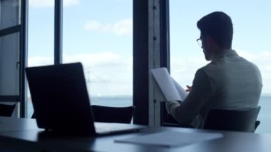 Ofis müdürü panorama penceresinin dikiz aynasındaki belgeleri kontrol ediyor. Adam deniz manzarası penceresinde gazete okuyor. Bilinmeyen iş adamı finans uzmanı şirket raporunu tutuyor. Yatırımcı anlaşmayı analiz ediyor.