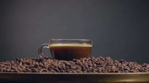 Full Kaffekopp Står Stora Högen Rostade Korn Närbild Aromatiska Droppar — Stockvideo
