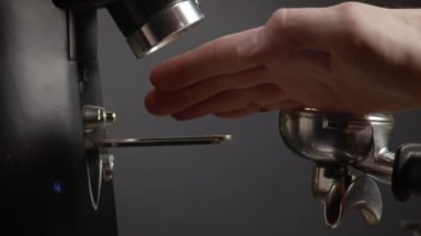 Kahve çekirdeklerini filtrede sıkıştıran barista eli. Portafilter 'de aromatik pudra seviyelendiren bilinmeyen bir adam enerjik bir içecek hazırlamaya hazırlanıyor. Espresso makinesinde kahve demleme işlemi