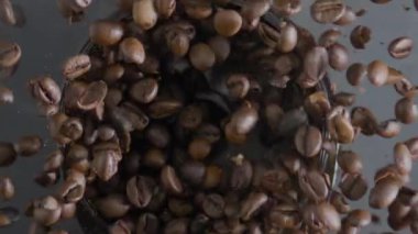 Kavrulmuş kahve çekirdekleri elektrikli öğütücüde dönüyorlar. Enerjik sabah içeceği yapmak için işlem hazırlama aromatik fasulyeler. Taze kahve çekirdeklerini öğütmek için modern ekipman.