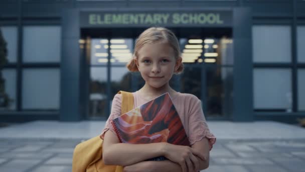 Little Elementary Age Girl Holding Books Posing Campus Door Close — Stock Video