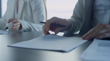 Ofisteki el kontrolü sözleşmesi. İş ortakları ayrıntıları analiz ederek sözleşmeyi okuyor. Bilinmeyen bir şirket müşterisi, elinde kalem çalışma kağıtları tutuyor. Mali işbirliği anlaşması kavramı.